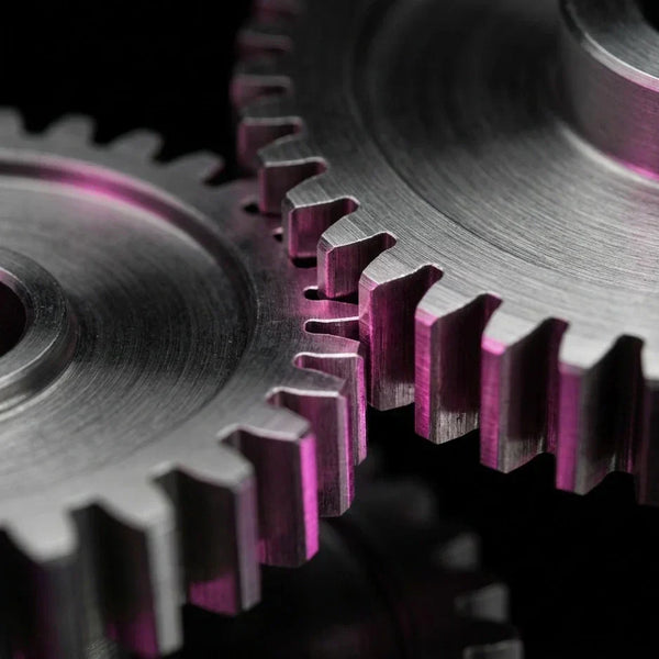Dettaglio macro ingegneristico di ingranaggi di precisione con luci magenta su sfondo nero, rappresentazione della solidità del codice conforme agli standard EAA 2026.